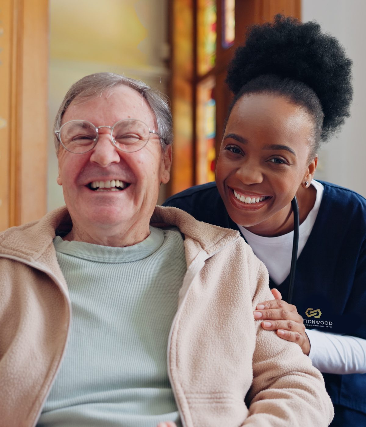 A Cottonwood caregiver with a smiling resident